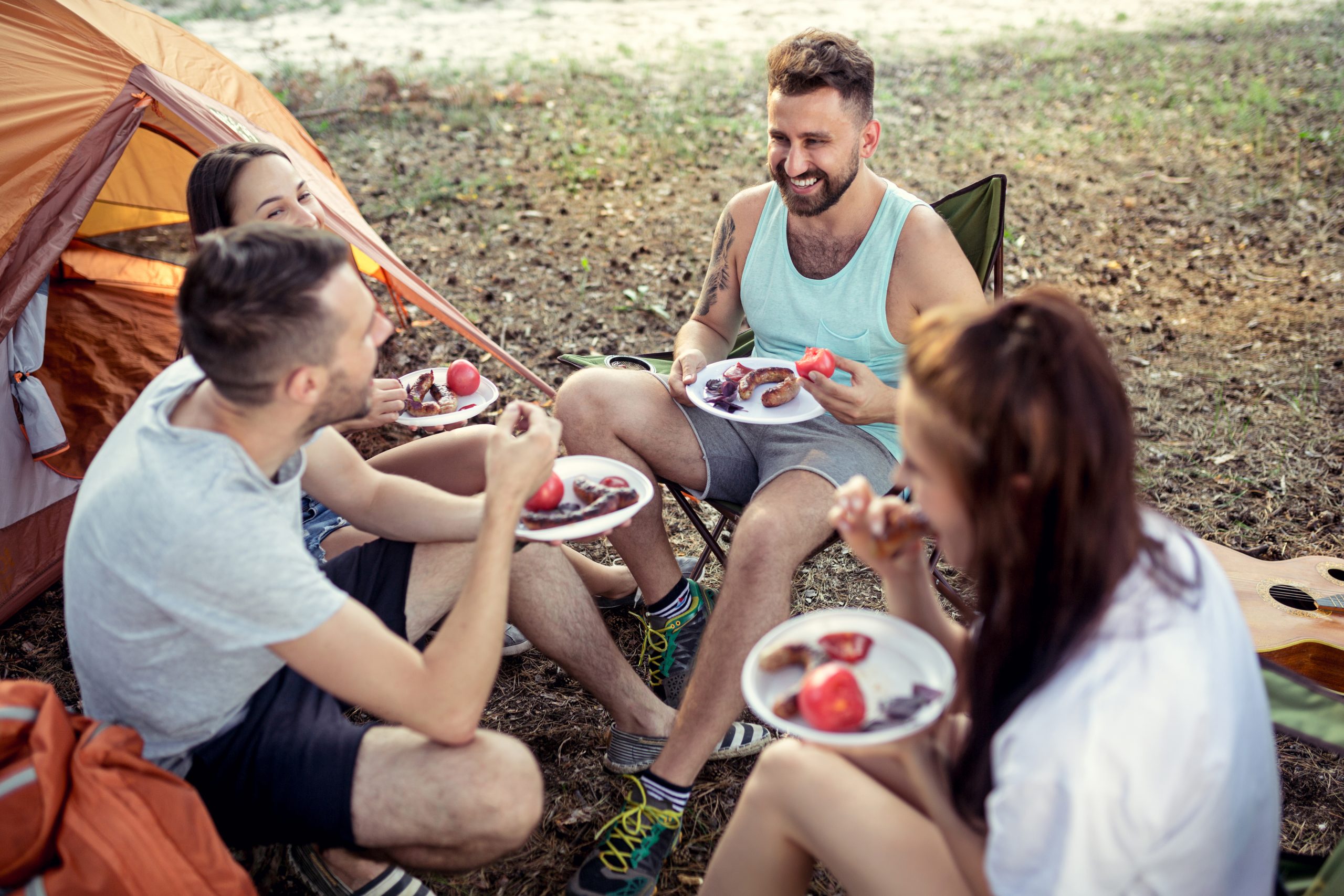 Party, camping of men and women group at forest. They relaxing and eating barbecue